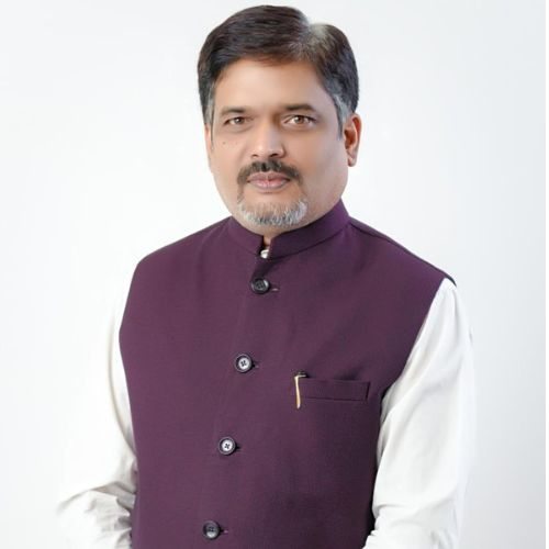 Dr. Abhijeet G. Shinde, physician and medical philosopher. Portrait in warm editorial lighting. White coat, calm expression, warm bookshelf background.